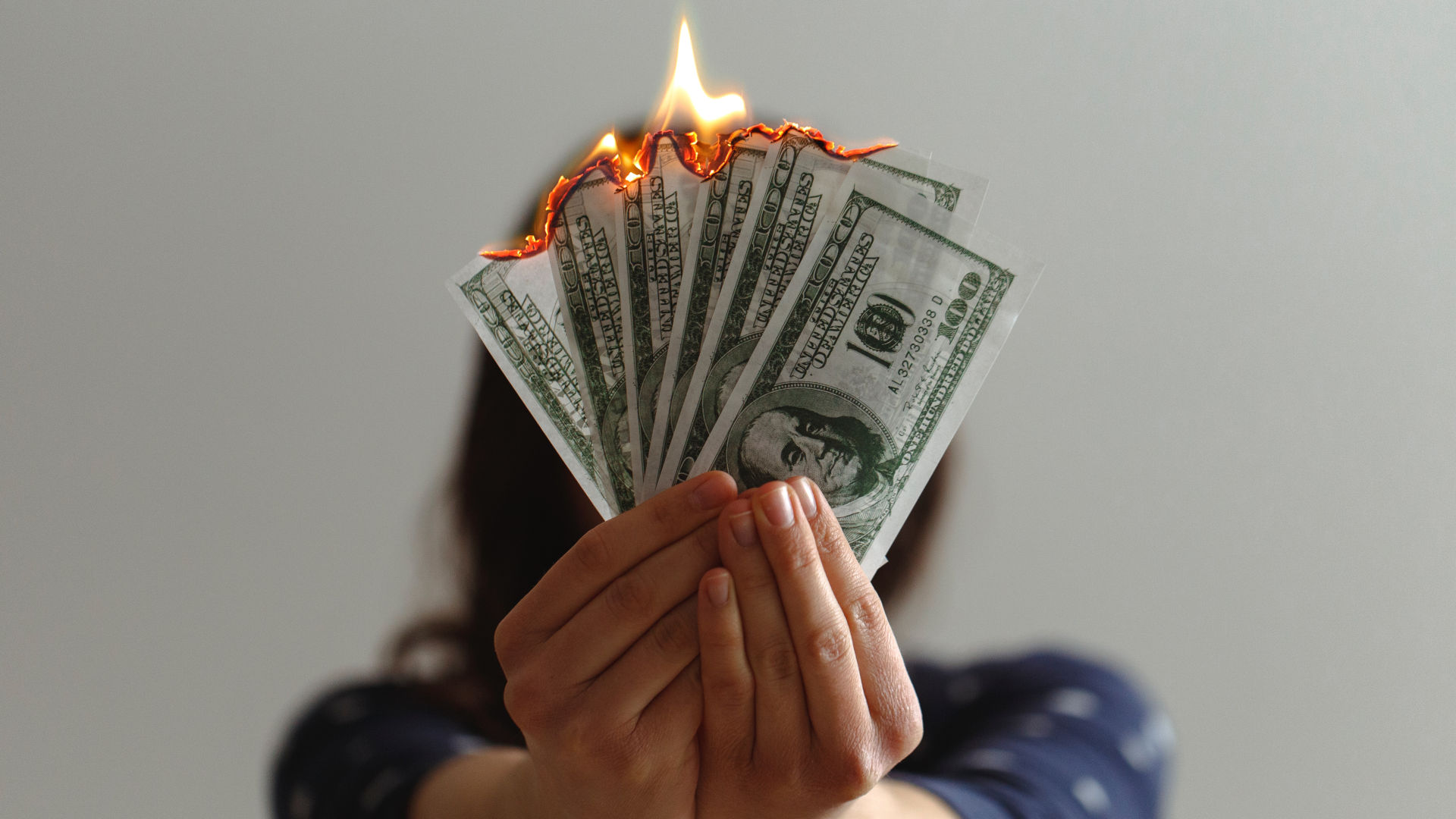 Lady Holding Burning $100 Bills